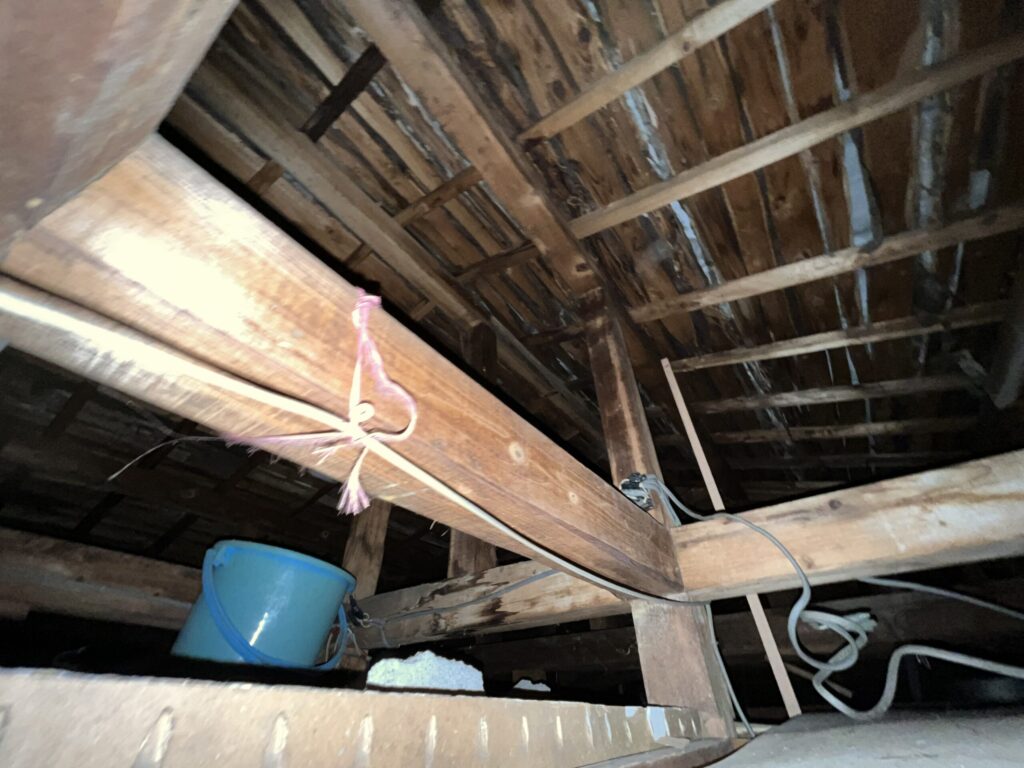 屋根裏で雨漏りをバケツで受ける応急処置|ルーフィング劣化=葺き替え工事が必要なサイン